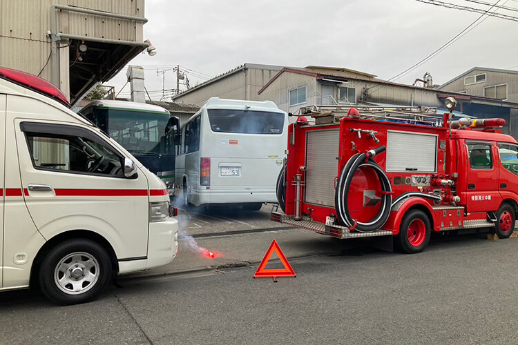 訓練中、停車を知らせる発煙筒で周囲に危険を知らせている様子